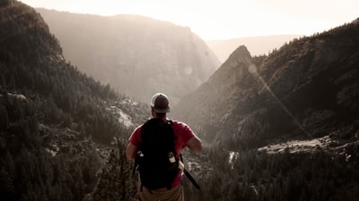 男人站在高架地面面临山白天
